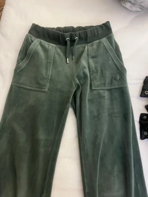 Gröna velourbyxor från Juicy Couture - Jättefina Juicy Couture byxor i storlek xxs. Tappat en metall sak på ena snöret men annars jättefina! 