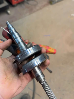 Metall vevaxel till motor - Säljer en vevaxel i metall, troligen till en mindre motor eller mopeddel. Den har svarvade ytor, splines och gängad topp. Perfekt för dig som gillar att meka eller behöver reservdelar till ditt motorprojekt.