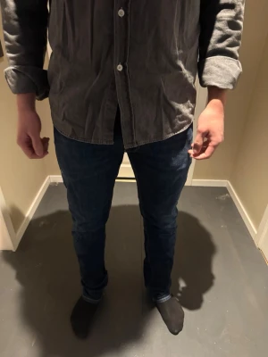 Replay Rocco 32 - Snygga mörkblå jeans med slim fit passform och klassisk femficksdesign. Jeansen har normal midja och raka ben, perfekta till en avslappnad stil. Tillverkade i ett mjukt denimtyg som ger både komfort och stil.