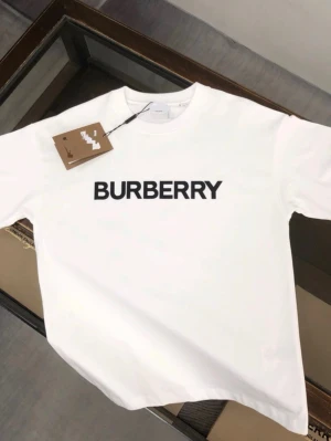 Vit Burberry t-shirt med logga - Säljer en clean vit t-shirt från Burberry med stor svart logga tryckt över bröstet. Klassisk rund halsringning och korta ärmar. Perfekt basic-plagg för dig som gillar stilrena designer och exklusiva märken.