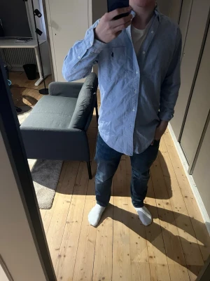 Ljusblå skjorta från Ralph Lauren - Klassisk ljusblå skjorta från Ralph Lauren. Skjortan är för stor för mig men passar om man är ca 180 cm väldigt bra. 8-9/10 i skick då den knappt använts. Hör av dig vid frågor! 