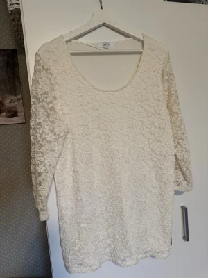 Vit spetsblus från ONLY - Stl. 44/46. Säljer en vit blus från ONLY med vackert spetsmönster och rund halsringning. Blusen har trekvartsärm och är perfekt för dig som gillar romantiska detaljer. Passar till både jeans och kjol för en trendig look.