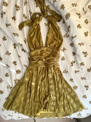 Cider halterneckklänning med spets och öppen rygg - Spetsklänning med halterneck och öppen rygg. Materialet ar stretchigt och det finns en dragkedja på sidan av klänningen. Gulgrön färg. Längd från bröstet: 64 cm 🌸 Total längd: 88 cm🌸Midja: 30 cm (ar dock mycket stretchigt material)