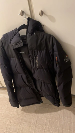 Svart dunjacka från Everest - Jacka är jätte fin finns lite små hål här och där men går att laga samt dragkedjan har fastnat se bild . Annat är den jätte fin i övrigt