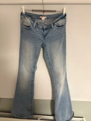 Ljusblå bootcut jeans  - ett par ljusblå bootcut jeans från Gina 14+ med snygg broderad bakficka i rosa och vitt. Jeansen har låg midja. Som nya!