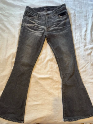   Svarta lowrise bootcut jeans - Säljer ett par lowrise jeans i tvättad svart denim. Modellen är bootcut, femficksdesign och låg midja. 