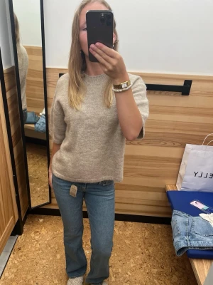 Blå bootcut jeans med låg midja - Säljer ett par klassiska blå bootcut jeans med hög midja och snygg passform. Jeansen är tillverkade i ett mjukt denim-material som är bekvämt att bära. 