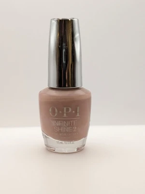 OPI Infinite Shine 2 Dulce de Leche nude nagellack 90% kvar - Snyggt nude-färgat nagellack från OPI Infinite Shine 2-serien. Lacket har en mjuk beige ton och kommer i en klassisk glasflaska med silverfärgat lock. Perfekt för en stilren och fräsch look. Innehåller 15 ml.