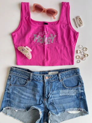 Y2K outfit bundle: baby tank + jeansshorts + accessoarer - stl M - Y2K inspirerad outfit bundle 🩵🌸✨  Kit med 6 delar: • rosa croppad topp med rhinestones (stl M) • low waist jeansshorts (stl 40) • y2k hårklämma • 2st hårspännen med pärlor • rosa faded solglasögon • guldiga ringar i olika stila. Varumärken: H&M, Gina Tricot.  Perfekt somrig Y2K outfit 💖 Alla plagg i fint skick! Kolla gärna in mina andra kit 💌 Fler bilder finns!