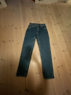 Blå raka jeans med hög midja - Säljer ett par klassiska blå jeans med rak passform och hög midja. Jeansen har fem fickor och stängs med dragkedja och knapp. Perfekta till en avslappnad stil och tillverkade i denim. Märke och storlek är ej angivet. Aldrig använda! Inga fel!💗💗💗