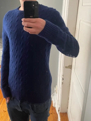 Mörkblå Kashmir tröja från Ralph Lauren - Mörkblå kabelstickad tröja från Polo Ralph Lauren i kashmir. 