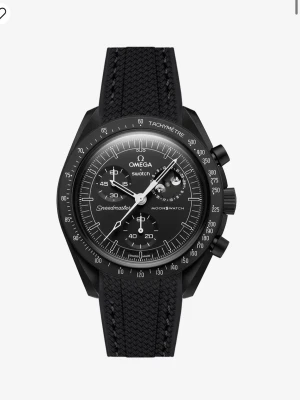 Omega x Swatch Speedmaster MoonSwatch - Snygg svart Omega x Swatch Speedmaster MoonSwatch med svart textilband och detaljerad urtavla med kronograf och tachymeter. Klockan har vit logga och markeringar, samt robust och sportig design. Perfekt för dig som gillar ikoniska klockor med cool look.