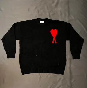 Ami Paris Sweatshirt  - Säljer en svart stickad tröja från Ami Paris med röd hjärtlogga. Priset är ej hugget i sten så skäms inte vid funderingar 