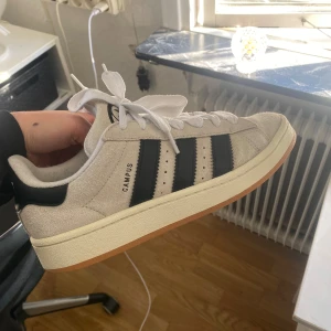 Adidas campus 00s crystal white  - Säljer ett par adidas campus 00s i strl 40 2/8, crystal white, adidas kartongen kommer med! Några defekter på insidan men inget som märks av eller syns utsidigt! Använda fåtal gånger och i bra skick! Säljer dessa för 800kr + frakt! 