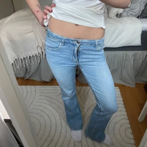 Low waist bootcut jeans - Snygga ljusblå bootcut jeans med låg midja. De har en klassisk femficksdesign och stängs med dragkedja och knapp. Perfekta för en avslappnad stil.
