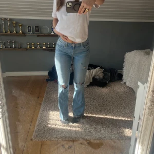 Low bootcut jeans  - Blåa Gina bootcut jeans med slitningar. Använda typ två gånger