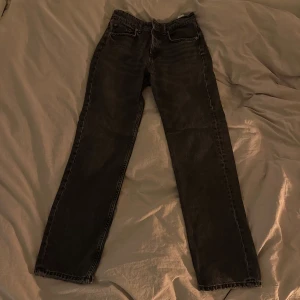 Svarta jeansbyxor - Snygga svarta jeansbyxor med klassisk femficksdesign och knappgylf. De har en rak passform och är perfekta för en avslappnad stil. Passar bra till olika outfits och tillfällen.