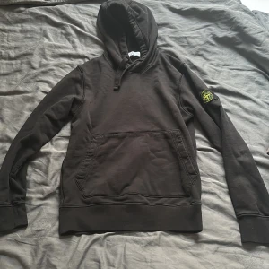Svart hoodie från Stone Island - Säljer nu en stilren svart hoodie från Stone Island! Tvär skön, sitter som en smäck🙌. Köpt på NK och är endast tre månader gammal. Perfekt för en avslappnad stil🗣️🗣️. Skriv om prisförslag eller flera bilder. Kvitto följer med🔥🔥🔥