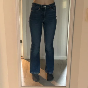 Mörkblå jeans med bootcut - Snygga mörkblå jeans med bootcut och hög midja. Perfekta för en avslappnad stil. Klassisk femficksdesign. Passar bra till både sneakers och klackar.