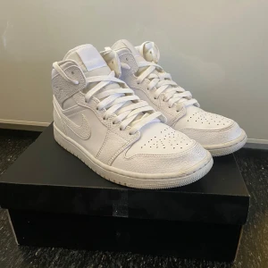 Air Jordan 1 mid  - Extremt fräscha helvita Nike Air Jordan 1 mid. ENDAST ANVÄNDA ETT TILLFÄLLE. Skorna är i storlek 42 och säljs pågrund av att dem är för små. Skorna kommer även med Orginal box (bild 5) skriv gärna om det finns några funderingar☺️