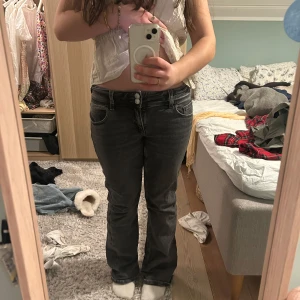 Grå bootcut jeans - Snygga grå bootcut jeans med låg midja och klassisk femficksdesign. Perfekta för en avslappnad stil. De har en dragkedja och knappar framtill. Är lite slitna nedtill. Skriv om ni vill ha bilder på det. 