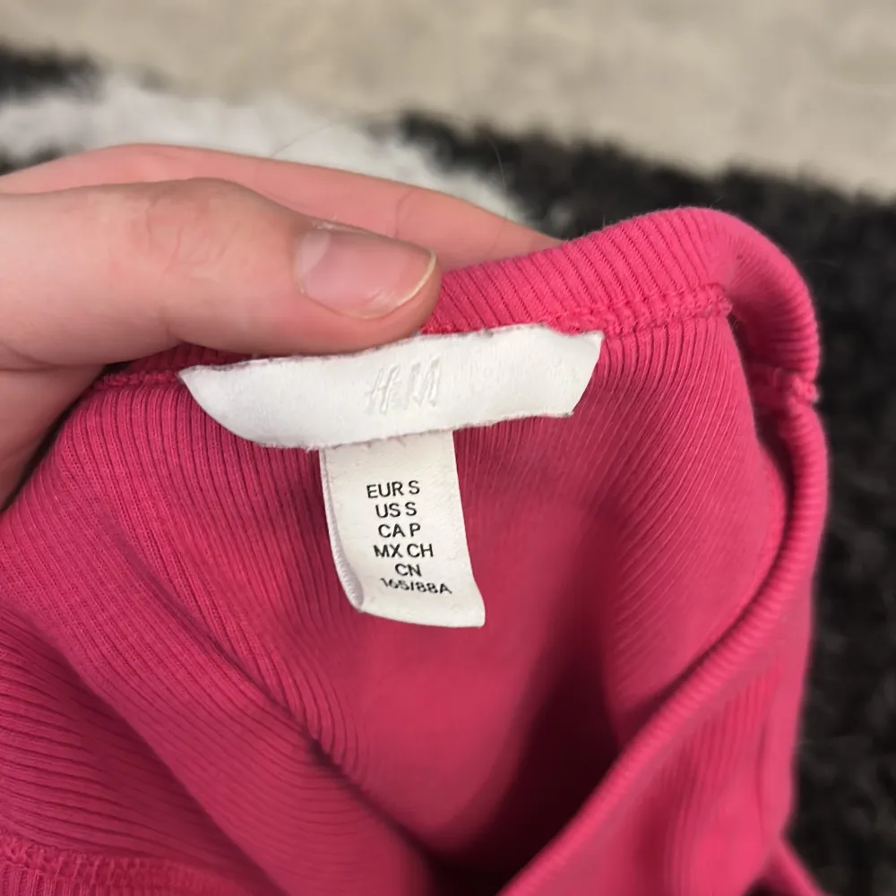 Säljer en snygg rosa ribbad linnetopp från H&M. Toppen är ärmlös och har en croppad passform, perfekt för varma dagar. Den är tillverkad i ett mjukt och stretchigt material som ger en bekväm känsla. Passar utmärkt till både jeans och kjol.. Yläosat.