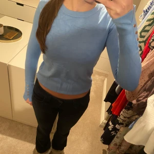 Ljusblå långärmad tröja - Säljer ljusblå långärmad tröja med guldknappar vid ärmen ifrån Zara i storlek S. 