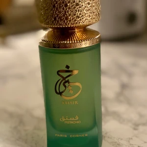 Khair Pistachio från Paris Corner - Elegant parfymflaska i frostat grönt glas med guldfärgad, detaljerad kork. Doften heter Khair Pistachio och har en lyxig känsla. Perfekt för den som söker en unik och sofistikerad doftupplevelse. Jättegod men inte min typ, tagit typ 10 sprut