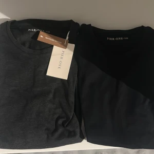 Svarta och mörkgrå långärmade tröjor från Pier One - Två stilrena långärmade tröjor från Pier One i svart och mörkgrått. Gråa har kappen kvar men den svarta har tyvärr inte det tror den har försvunnit, både tröjorna är oanvända och ser nya ut, perfekt för en chill dag eller träning. Säljer båda för 300 eller 150 styck 