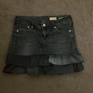 Svart jeanskjol med volang - Har sytt om kjolen från jeans till jeans kjol men säljer då den är lite förstor. Den är 35 cm lång och den är mörkblå.