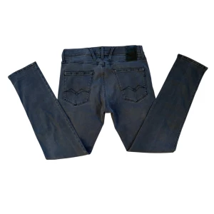 Grå Replay Jeans - Snygga grå jeansbyxor från Replay med en klassisk femficksdesign. Byxorna har en knappgylf och bälteshällor. Märkesdetaljer syns på bakfickan och i midjan. Perfekta för en stilren look. Dem är i modellen Anbass och är riktigt snygga ‼️ Skicka gärna frågor eller prisförslag till mig😇 FÖRST TILL KVARN‼️