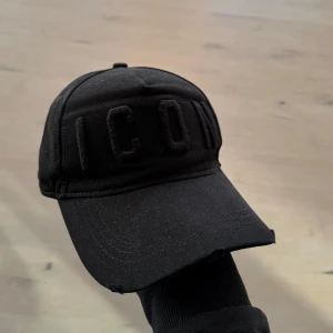 Svart keps från Dsquared2 - Säljer nu min Snygg svarta keps från Dsquared2 med texten 'ICON' broderad framtill|Kepsen har en justerbar rem baktill för perfekt passform|Nypris på 1400kr|Skick 9/10|Pris diskuterbart vid snabb affär|vid fler frågor är de bara att skicka MVH Albin