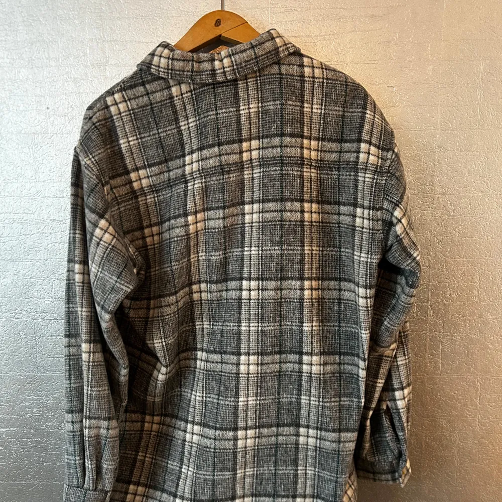 Snygg grå rutig overshirt från JUNKYARD. Jackan har långa ärmar och knappar framtill. Perfekt nu till höst och vår. Overshirten är oanvänd och har superskönt material. Passar M/ S. Takit.