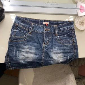 Jeanskjol från ONLY - Snygg jeanskjol från ONLY i klassisk blå denim med slitna detaljer. Kjolen har fyra fickor och en knappgylf. Perfekt för en avslappnad look. Midjemått är 38 cm 💞