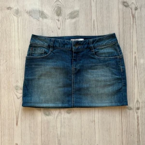 Blå lågmidjad jeanskjol  - Lågmidjad jeanskjol från ESPRIT som jag har sytt upp från en längre kjol. Kan inte hitta storlek men skulle säga S/M. Tvärs över midjan är det 38 cm + stretch, och längs med sidan är det ca 32 cm. Fint skick. Använd gärna köp nu!