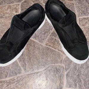 Arigatos - Snygga svarta sneakers från Arganto med vit sula. Skorna har en stilren design utan snörning, vilket gör dem enkla att ta på och av. Perfekta för en avslappnad stil.