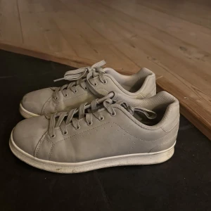 Grå sneakers med snörning - Snygga grå sneakers med klassisk design och snörning. Perfekta för en avslappnad stil. De har en enkel och stilren look som passar till det mesta.