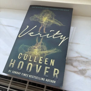 Verity - Spännande bok av Colleen Hoover, 'Verity', som lovar att hålla dig vaken hela natten. Perfekt för dig som älskar thrillers med oväntade vändningar. Boken är i pocketformat och har en fängslande framsida med en mystisk illustration. I relativt bra skick.