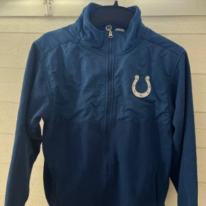 Blå fleecejacka från NFL Team Apparel - Säljer en blå fleecejacka från NFL Team Apparel med dragkedja 