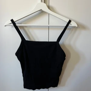 Svart ribbad topp - svart ribbad topp med smala axelband. 