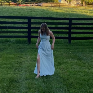 Ljusblå balklänning med slits - Jättesöt ljusblå långklänning med smala axelband och en stilren slits. Perfekt som balklänning!🩵🌻Endast använd en gång, men lite missfärgning vid armhålorna pga deo finns (se bild). Klänningen är från sidan jjshouse, hittar dock inte exakt denna klänning på hemsidan längre, köpt 2022. Nypris var ca 1200kr. Storlek S/34-36! Uppsydd en knapp centimeter, passar perfekt dig som är omkring 165 cm lång! 🩵Köpare står för frakt📦 