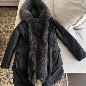 Woolrich arctic down army parka - Arctic Army Parka från Woolrich i storlek. S med snygg tvättbjörnspälskant  Fyllning: 90% anddun, 10% fjädrar Pälskant: tvättbjörn.    Ny pris: 14 000 kr 