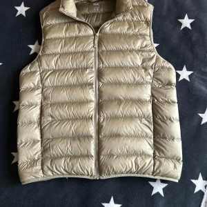 Beige dunväst från Uniqlo - Säljer en beige väst från Uniqlo i storlek s. Väldigt snygg och prefekt till sommaren pis 279 kr. 