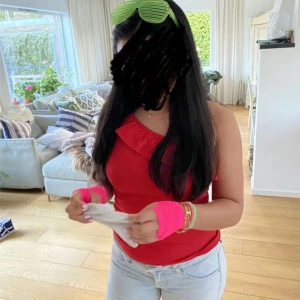 Röd one shoulder topp med volang - Säljer en röd one shoulder topp med volangdetalj längs halsen. Perfekt till tema, fest och sommaren! Storlek XXS men passar även större storlekar!!