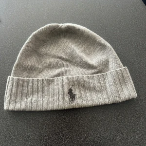 Ljusgrå mössa från Ralph Lauren - En grå mössa från Ralph lauren. Bara blivit liggandes i garderoben. Nypris 800