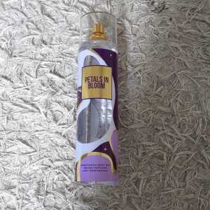 Petals in Bloom Body Mist - En stor body mist med namnet Petals in Bloom. Flaskan är transparent med lila, guld och vita detaljer samt ett guldigt spraymunstycke. Rymmer 235 ml och har en modern, stilren design med stjärnmotiv på etiketten. Jag köpte den utomlands men jag är inte jätteförtjust i doften☺️