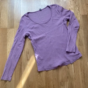 Ljuslila långärmad topp från Esprit - Säljer en ljuslila långärmad topp från Esprit. Tröjan har en rund halsringning och är tillverkad i ett mjukt, tunt material som passar perfekt till vardags. Enkel och stilren design som är lätt att matcha med olika outfits.