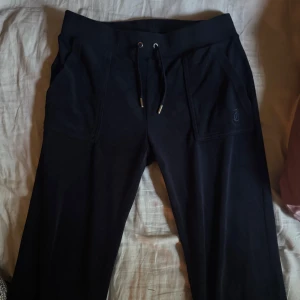 Svarta mjukisbyxor från Juicy Couture - Mörkblå mjukisbyxor från Juicy Couture med dragsko i midjan och fickor både fram och bak.