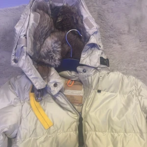 Beige dunjacka från Parajumpers - Säljer en snygg beige vinterjacka  från Parajumpers. Väldigt bra skick, använt få gånger då jag inte gillar långa jackor. Man kan välja att ta av luvan om man vill. Inuti luvan finns fluffig mjuk päls. Jackan är väldigt varm och perfekt  till vintern. Storlek S 