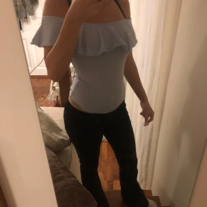 Ljusblå offshoulder volang body - Säljer en ljusblå body med offshoulder-design och bred volang runt överdelen. Perfekt för dig som vill ha en trendig och stilren look till fester eller i skolan. Snygg och bekväm passform💗💗
